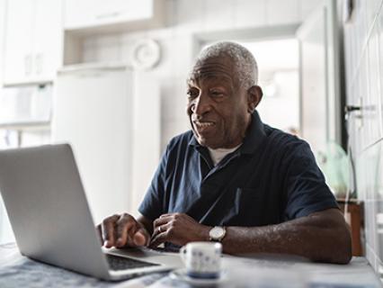 A man with grey hair uses a computer